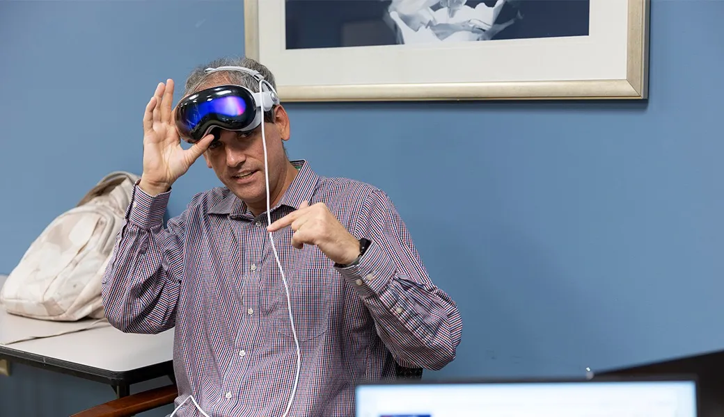 Kyle Johnsen holding a virtual reality headset.