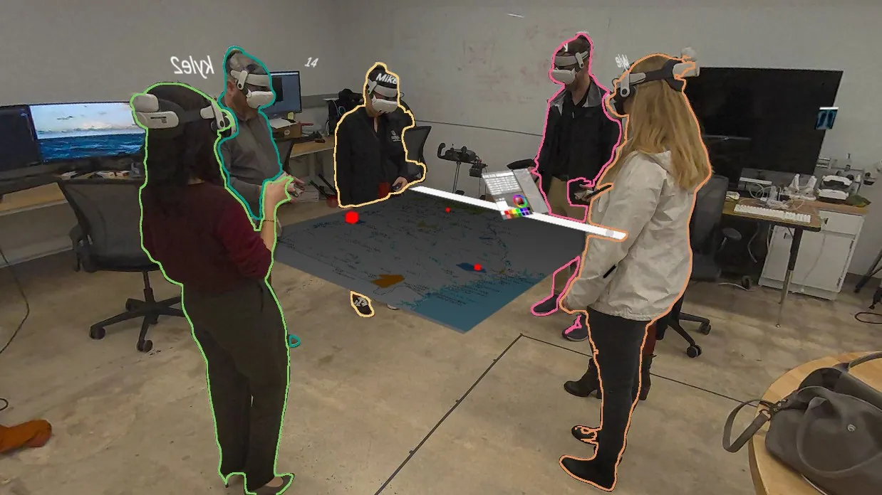 People in headsets around a shared map in Drawn Together.