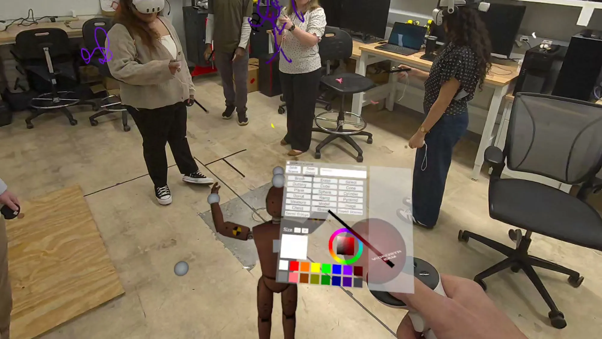 People in the lab working with shared 3D models and a color palette.