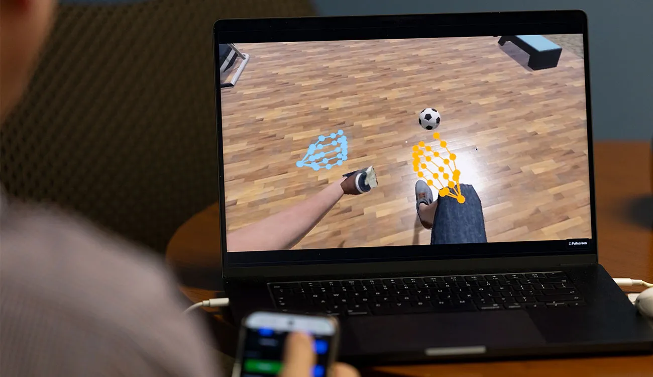 A laptop shows the virtual reality limb exercise the patient sees in the headset.